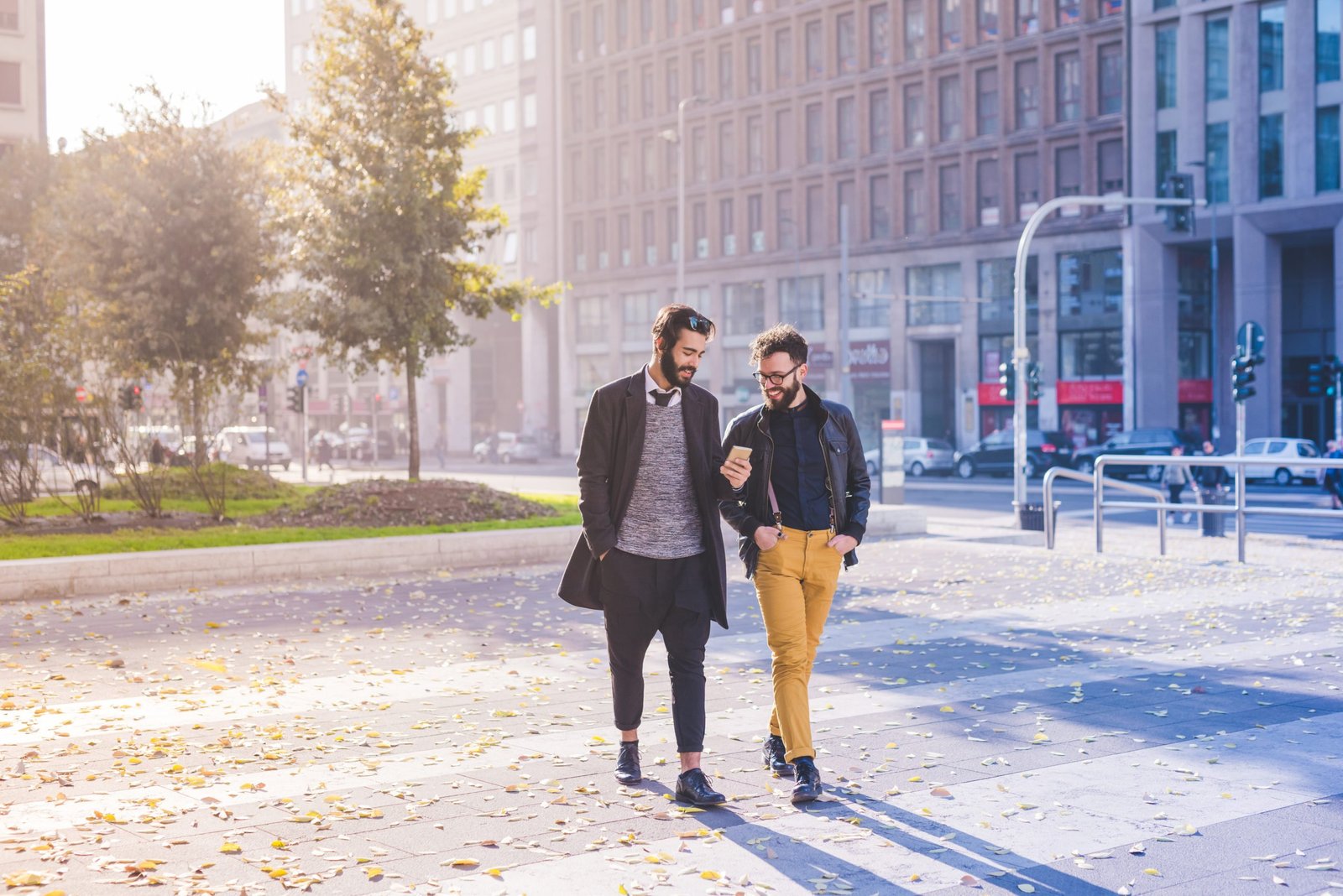 graphicstock-two-young-bearded-blonde-and-black-hair-modern-businessman-walking-in-the-city-using-smart-phone-working-successful-concept_H6HGh1Ykb-scaled.jpg