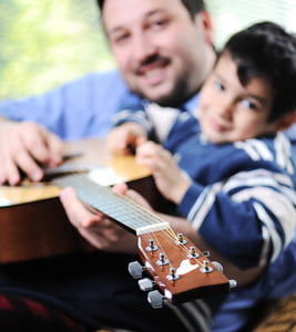 father-and-son-playing-guitar-at-home_HYBn7NaBo_thumb.jpg