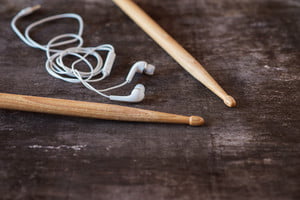 graphicstock-drumsticks-and-earphones-laid-on-a-wooden-desk-background_HAVpXKpW-_thumb.jpg